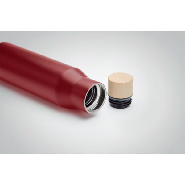 Maroon water bottle laid down on desk with lid kept outside